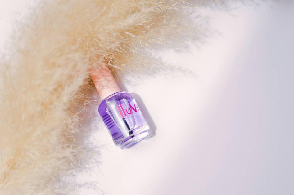 Close-up of neatly applied nude nail polish primer on manicured hands